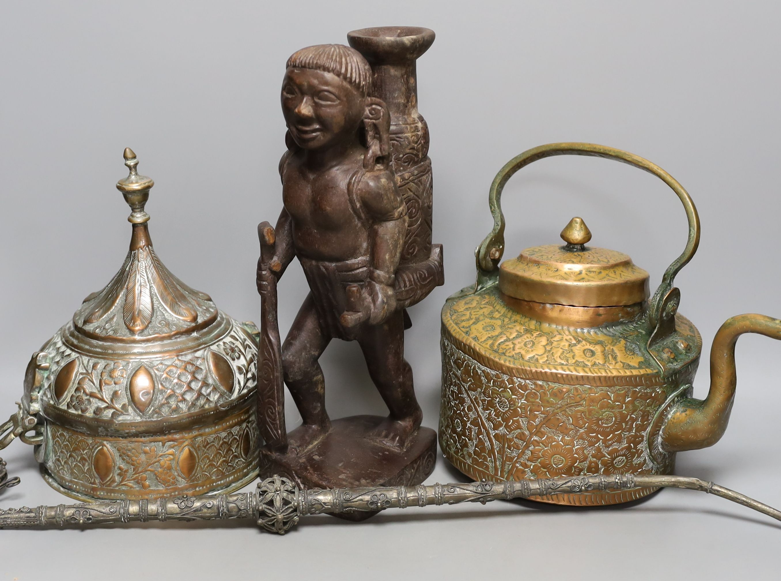 A group of Middle Eastern metalware, a kris, a jambiya, and a figurative carving, 31 cms high.